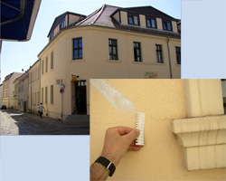 Rissbreitenmessung an der Fassade eines Gebäudes mit Rissschablone